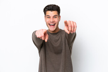 Young handsome caucasian man isolated on white bakcground surprised and pointing front