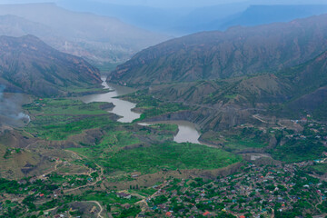 foggy mountain valley with river, villages and fields