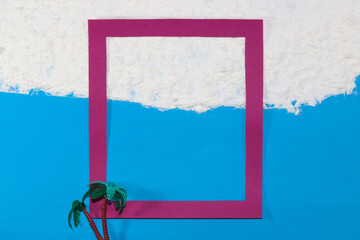 pink frame on the beach half in the water half on the sand with palm tree, creative tropical design, copy space in the frame, idyllic vacation picture, minimal concept