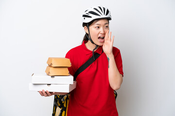 Young Chinese delivery woman taking takeaway food isolated on white background shouting with mouth wide open to the side