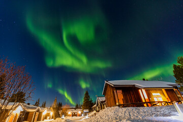 Case nella notte sotto l'aurora boreale a Kiruna in Svezia. Freddo,,neve e gelo e luci nella notte polare.
