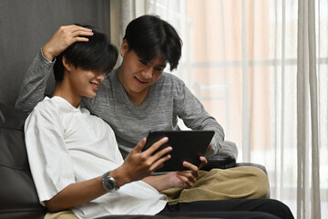Homosexual couple, Thailand gay men laughing while looking at tablet, LGBT couples and Everyday life at home concept.