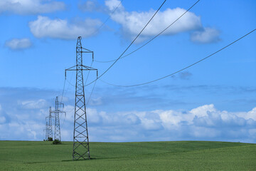  Linia elektryczna wysokiego napięcia na tle błękitnego nieba.