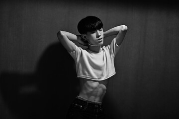 Black and white photo of slim Asian cross-dresser,male with black short-straight hair wear crop-top...