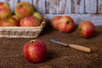 Ripe apples on burlap and in a basket. Rustic style, close-up.