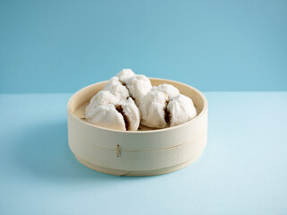 steamed BBQ Honey Pork Bun served in a tray with chopsticks isolated on mat side view on grey marble background