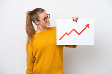 Young caucasian woman isolated on white background holding a sign with a growing statistics arrow symbol with happy expression