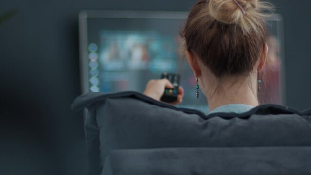 TV watch at home. Woman searches show on online streaming service and scrolls the screen