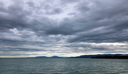 Beautiful dramatic summer cloudscape over Flathead Lake in Montana on calm June day.