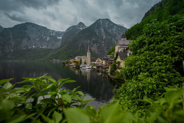 Beautiful view of Hallstatt, Austria, picturesque village on the edge of a lake. Classical view looking through the window in a bush.