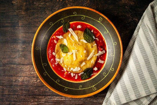Ricotta ravioli with honey, walnuts and chives in cherry tomato sauce