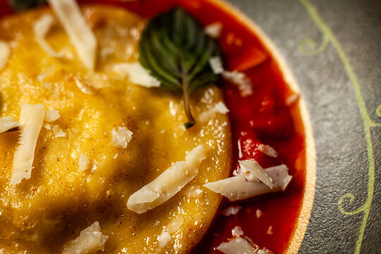 Ricotta ravioli with honey, walnuts and chives in cherry tomato sauce