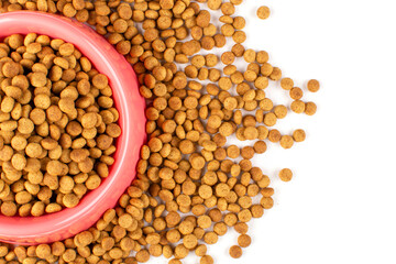 Pink bowl with dry food for a cat (dog) close-up on a white isolated background. Space for text. Balanced nutrition of pets.