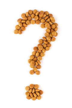 A question mark laid out of dry food for cats (dogs) on a white isolated background. Balanced nutrition of pets.