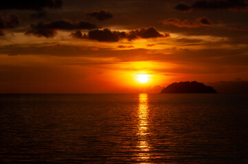 Fototapeta premium Colorful beach sunset view with island background. Copy space