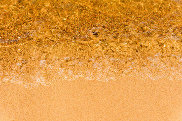 Abstract Transparent and clean yellow water background with sunlight reflection, top view,summer natural day shot.Copy space.