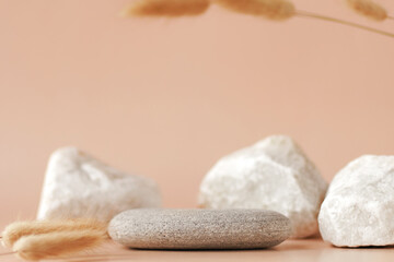 Stone podium with dry flowers on beige background. Beauty mockup composition. Concept of natural and organic skincare products presentation