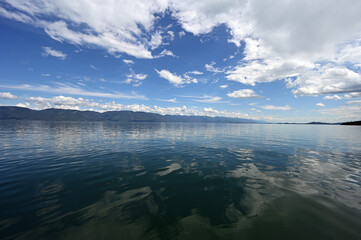 Beautiful dramatic summer cloudscape over Flathead Lake in Montana on calm June day.