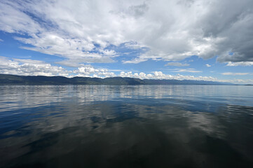 Beautiful dramatic summer cloudscape over Flathead Lake in Montana on calm June day.