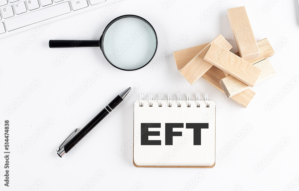 Poster eft word written on notebook with block magnifier and pen , business concept.