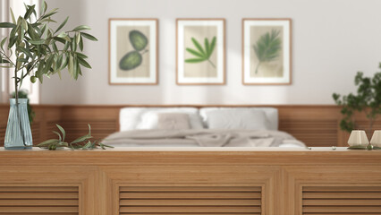 Wooden table top, cabinet, panel or shelf with shutters close up. Olive branch in vase and candles. Blurred background with white modern bedroom, interior design