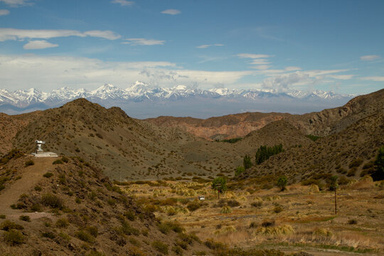 Alpine Landscape. View Of The Arid Valley And Andes Cordillera Mountains In The Horizon, Under A Beautiful Blue Sky In Pampa Del Leoncito, San Juan, Argentina. 