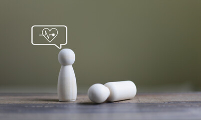 The wooden doll fell down with a heart attack. health care acute, heart failure concept