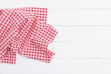 Kitchen red and white checkered tablecloth on white wooden empty space background. Red and white checkered fabric pattern.