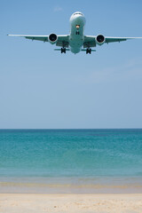 Fototapeta na wymiar A plane is landing near white beach