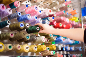 Colorful cones and spools of thread at an atelier.Tailoring, garment industry, designer workshop concept.