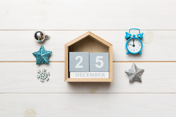 Christmas wood calendar with new year decorations, aganist colored background. Christmas calendar 25 desember