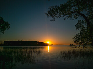 Fototapeta na wymiar Sunset over the lake. Evening summer landscape.