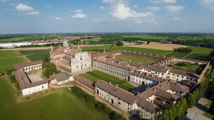 Fototapeta na wymiar Aerial view of the Certosa di Pavia at sunny day, built in the late fourteenth century, courts and the cloister of the monastery and shrine in the province of Pavia, Lombardia, Italy