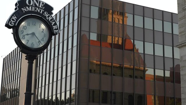 Clock in front of Historic Wood County courthouse in Parkersburg, West Virginia, WV with reflection of the building.