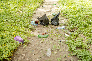 Scattered plastic garbage on a dried river in the woods. Problem of ecology and environmental pollution