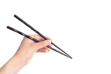 Hand holding black chopsticks isolated on white