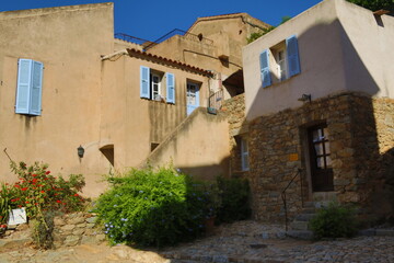 Fototapeta na wymiar courtyard with houses, blue shutters, Corsica, France