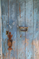 Blue wooden door with vertical planking with an old rusty door catch and lock, Corsica, France