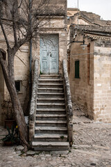 Abandoned staircase leading to a closed door in the typical Italian town of Matera, Southern Italy