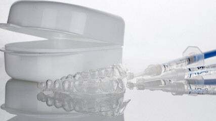 dental composition from a cap on both jaws for whitening with a case and syringes with gel on a...