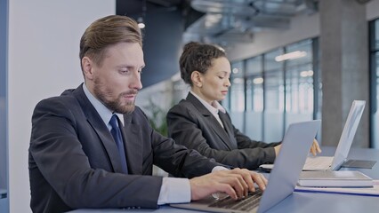 Male and female colleagues working on laptop, analyzing data online, office work