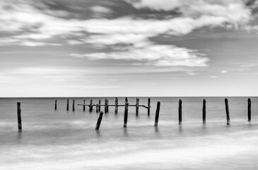 black and white long exposure view of old abandoned sea defenses on Happisburgh Beach