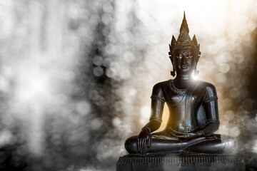 Buddha statue made of bronze ancient shape on a white light bokeh background