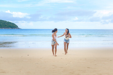 Two attractive women friends enjoying and relaxing on the beach,  Summer, vacation, holidays, Lifestyles concept.