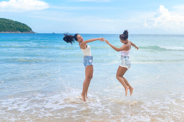 Two attractive women friends enjoying and relaxing on the beach,  Summer, vacation, holidays, Lifestyles concept.