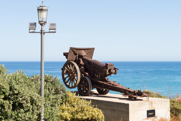 Fototapeta na wymiar Artillery cannon on display at the Parque de la Bateria in Torremolinos (Malaga, Spain). Antique artillery cannon belonging to an old defence battery. Mobile cannon with hypomobile traction.