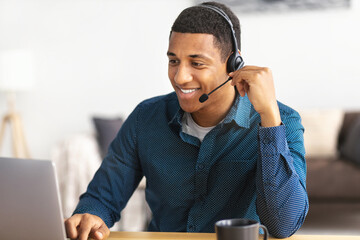 African american young man customer support call center operator or receptionist sitting at the...