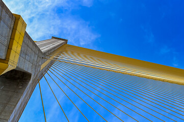 Bhumibol Bridge in Thailand with bright blue sky as background