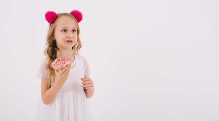 Funny little girl eating a donut on a white background