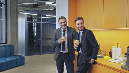 Male colleagues having fun during coffee break in office, informal communication